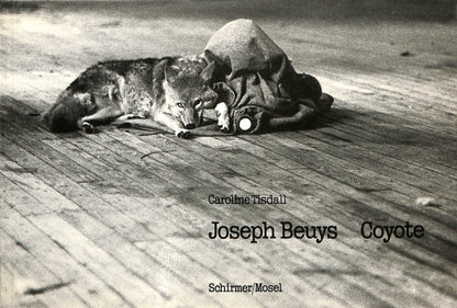 Cover - CAROLINE TISDALL / JOSEPH BEUYS: COYOTE. Black and white photograph of a person lying on the ground with a coyote, featuring text about Joseph Beuys and Caroline Tisdall.