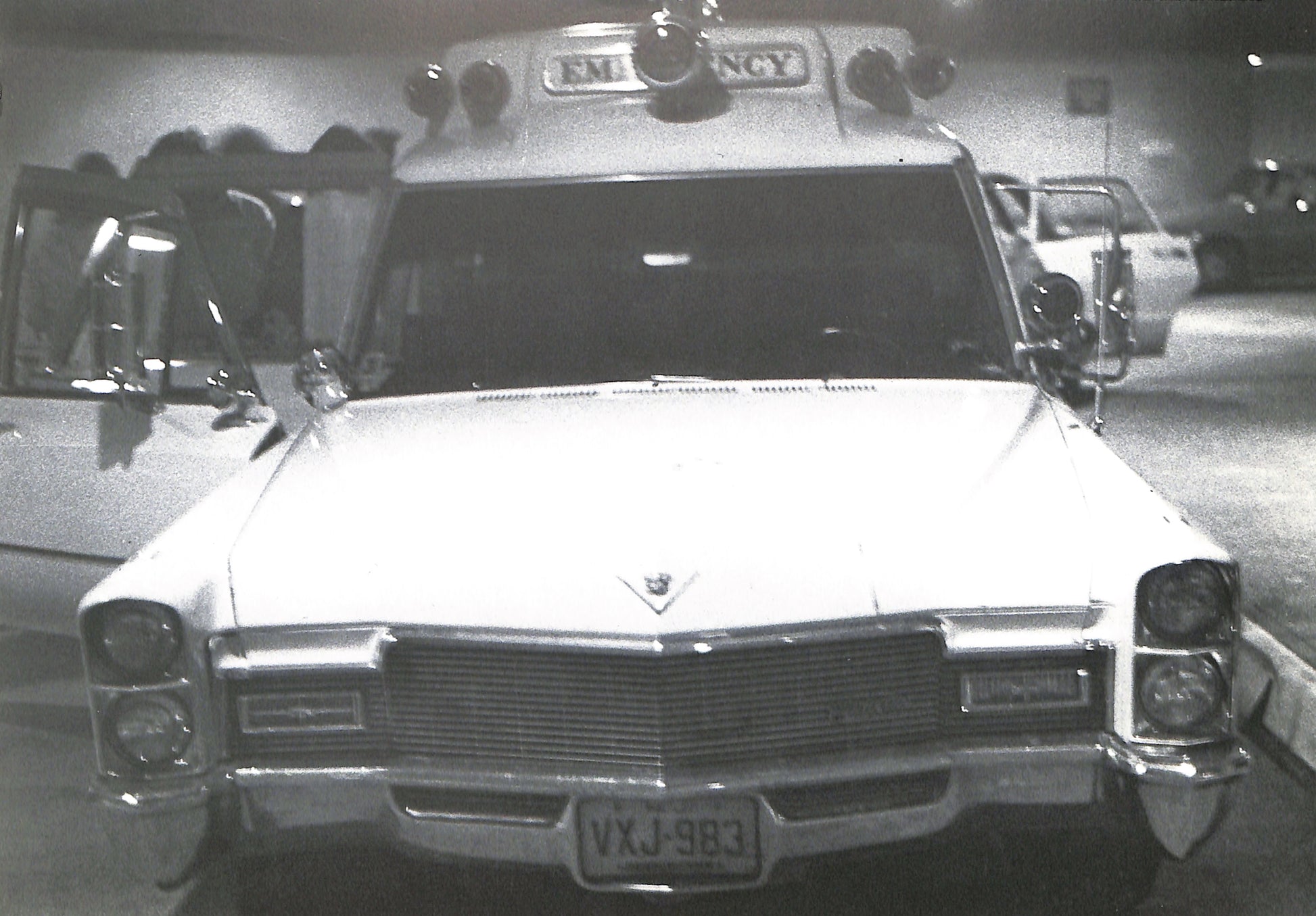 Interior - CAROLINE TISDALL / JOSEPH BEUYS: COYOTE. Vintage ambulance with 'EMERGENCY' sign on top, parked indoors.