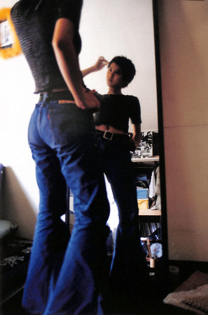 Interior shot - YURIE NAGASHIMA / YURIE NAGASHIMA. Person wearing blue jeans standing in front of a mirror with a reflection.